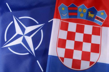 LVIV, UKRAINE - 03 Eylül 2024: NATO ve Hırvatistan 'ın bayrakları, iki taraf arasındaki ortaklığı simgeleyen şekilde yan yana gösteriliyor. Kalın renkler ve belirgin tasarımlar açıkça görülebilir..