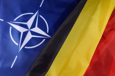 LVIV, UKRAINE - 03 Eylül 2024: NATO ve Belçika 'nın bayrakları, küresel savunma girişimlerindeki işbirliği ve takım çalışmalarını sembolize eden uluslararası bir güvenlik toplantısında ittifaklarını belirgin bir şekilde gösteriyor.