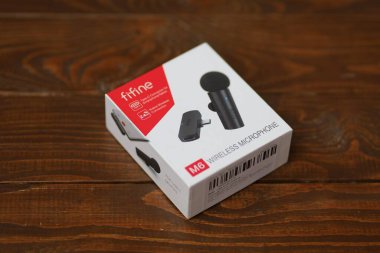 LVIV, UKRAINE - 09 Eylül 2024: Ahşap bir masada parlak bir kablosuz mikrofon paketi sergileniyor