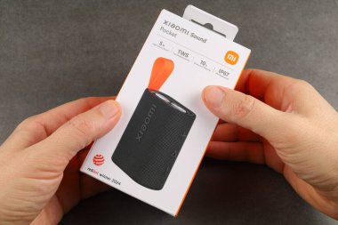 LVIV, UKRAINE - 09 Eylül 2024: Bir kişi Xiaomi Pocket ses aygıtı paketleme, parlak tasarım ve özelliklerini gösteren bir cihaz tutuyor.
