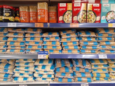 LVIV, UKRAINE - 13 Ocak 2025: Düzenli istiflenmiş bulgur, pirinç ve diğer tahıllar, gündüz alışveriş saatlerinde bir marketteki rafları dolduruyor.