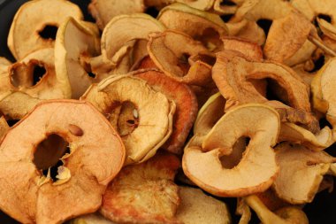 Lezzetli kurutulmuş elma dilimleri, sonbahar hasadı boyunca abur cubur veya yemek tarifleri için mükemmel renkler ve dokular sergiler..