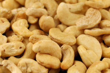 Kaju fıstıkları yakın planda sunulur. Yumuşak dokularını ve açık renklerini göstererek doğal cazibelerini ve besin değerlerini vurgularlar..