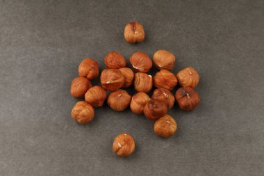 Koyu bir yüzeye yerleştirilmiş fındıklar toprak tonlarını ve eşsiz şekillerini sergiler. Mutfak kullanımı ve atıştırma için mükemmeldir..