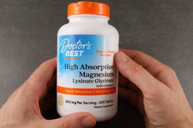 LVIV, UKRAINE - September 30, 2025: Hands hold a bottle of high absorption magnesium for muscle support and sleep aid.