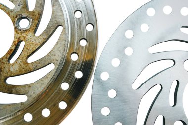 Yeni ve eski motorsiklet disk frenleri karşılaştırıldığında metal disk frenleri soğutmak için deliklere sahiptir. Beyaz arkaplanda izole edilmiş nesne