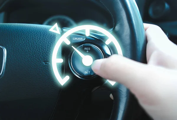 Automotive cruise control system on the steering wheel of the car with speedometer lock indicator and driver hand