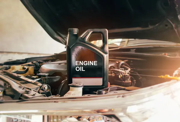 Car engine oil gallon or lubricate oil gallon on car engine compartment with sunlight Car maintenance and oil lubricant concept