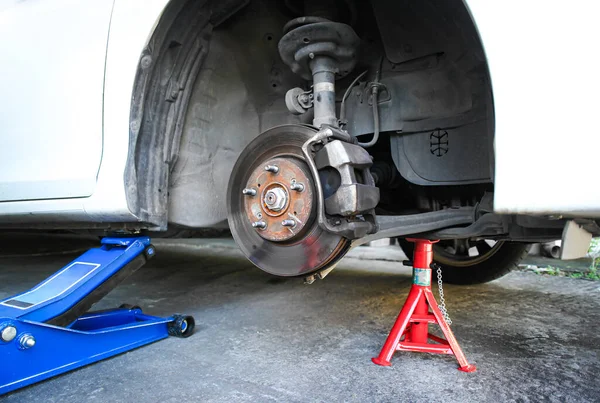 Car brake discs without wheels , Lift the car with the hydraulic car jack and jack stand in the car repair shop to repair the brake system