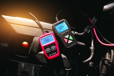 Motor bölmesinde pil testi ve OBD veya OBD2 tarayıcı, araba bakım hizmeti konsepti