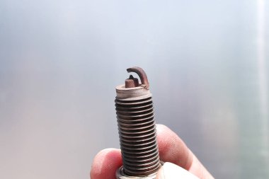 Dirty and damaged spark plugs , close up of old spark plugs of car combustion engine in the hands of car mechanic , Car repair concept clipart