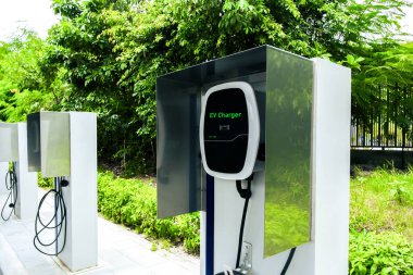 Yeşil ortamda elektrikli araç şarj istasyonu, elektrikli araç teknolojisi kavramı