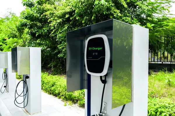 Yeşil ortamda elektrikli araç şarj istasyonu, elektrikli araç teknolojisi kavramı