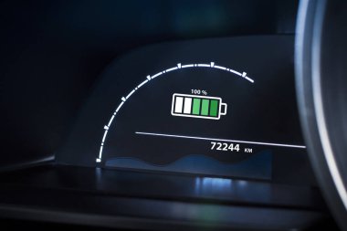 Elektrikli araç gösterge paneli% 100 şarj olduğunu gösteriyor. EV, yeşil enerji, sürdürülebilir ulaşım teknolojisi.