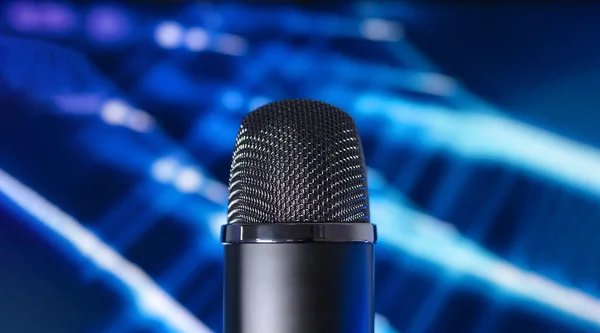 Condenser microphone on a blue tech background. Concept recording audio podcast.