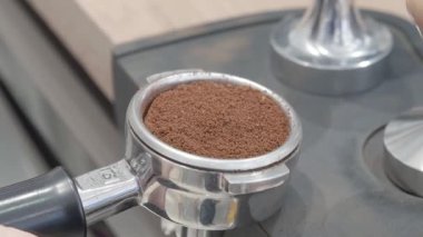 Kahve makinesinde zengin bir espresso hazırlamaya hazır, mükemmel doldurulmuş kahve telveleri olan bir iskele filtresinin videosu..