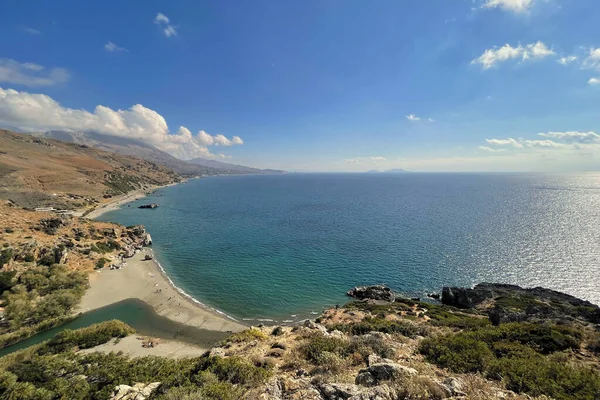 Girit adasında dağları olan Preveli palmiye plajı ve nehir manzarası.