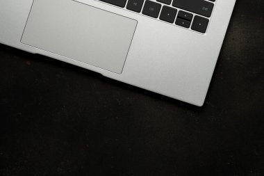 Siyah arkaplanda dizüstü bilgisayarın üst görüntüsü. Düz uzanmış, üst görünüm ofis masası..