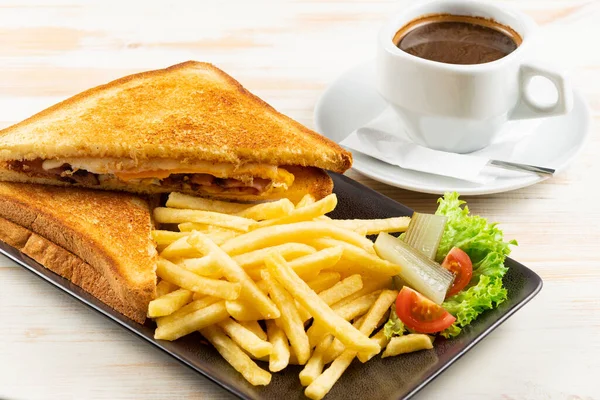 Breakfast toast with bacon, cheese, pan fried potatoes and cup of coffee. Food background.