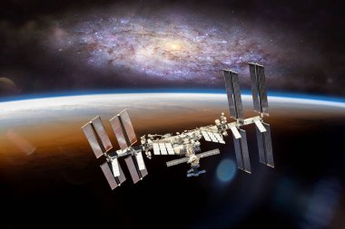 Dünya gezegeninin yörüngesindeki uluslararası uzay istasyonu. Yıldızları ve galaksileri olan UUİ. Bu görüntünün elementleri NASA tarafından desteklenmektedir.
