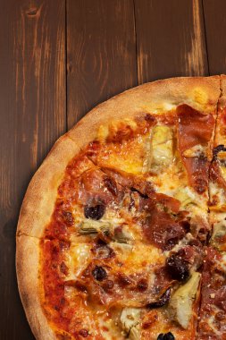 Domates soslu pizza, karışık peynir seçimi, jambon, pepperoni, pastırma, taze mantar ve zeytin..