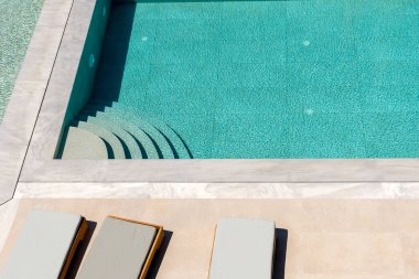 Güneş yataklı yüzme havuzunun en üst manzarası. Yaz arkaplanı.