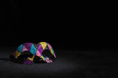 Siyah arka planda parıltılar olan karnaval maskesi.