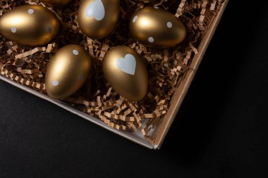 Masadaki karton kutuda altın yumurtalar. Üst görünüm.