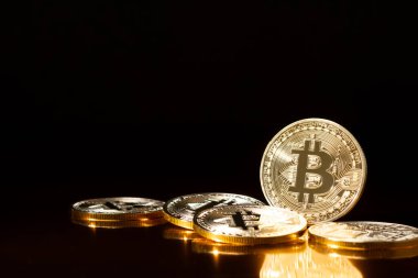 Bitcoin kripto altın sikkeleri siyah arkaplanda.