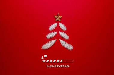 Kırmızı arka planda Noel ağacı ve şeker kamışı. Yaratıcı Asgari Noel Yükleme Konsepti.