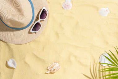 Deniz kabukları, şapka ve kumdaki güneş gözlükleri. Kopya alanı olan deniz yaz tatili arka planı.