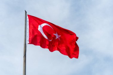 Türk ulusal bayrağı gökyüzü arka planında bir direğe asılı.