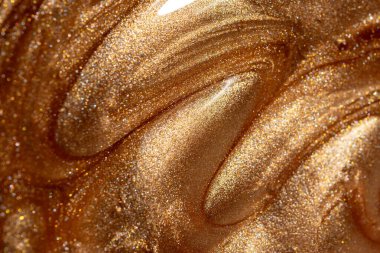 Altından parıldayan kozmetik vücut spreyi ya da jöle ile doku arkaplanı. Parlak arkaplan.