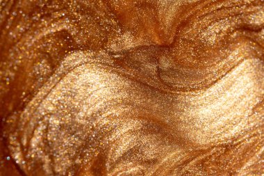 Altından parıldayan kozmetik vücut spreyi ya da jöle ile doku arkaplanı. Parlak arkaplan.