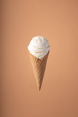 Parlak arka planda dondurma koni ile dondurma kepçe. Minimal yaz konsepti.