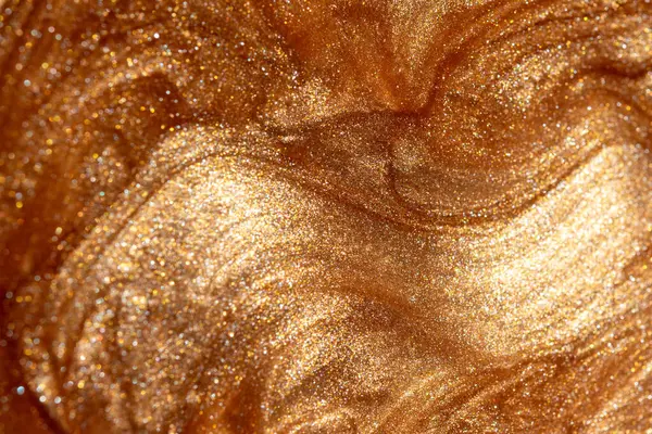 Altından parıldayan kozmetik vücut spreyi ya da jöle ile doku arkaplanı. Parlak arkaplan.