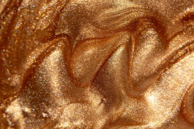 Parlayan altın parıldayan kozmetik jel veya vücut spreyi dokusu. Arkaplan veya haritalama için arkaplan dokusu.