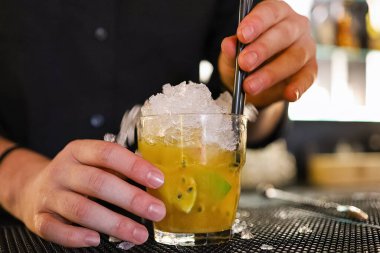 Barmen, gece kulübünde klasik kokteyl bardaklarıyla kokteyl yapıyor..