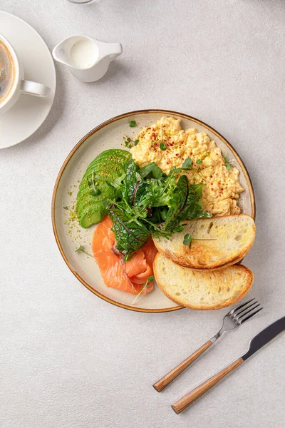 stock image Portion of scrambled eggs breakfast with salmon and avocado