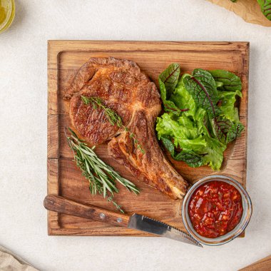 Bir porsiyon salata ve soslu baltalı biftek.