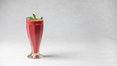 Beyaz arka planda nane aromalı bir bardak taze meyve suyu.