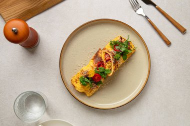 Portion of gourmet omelette with tomatoes, basil and parmesan