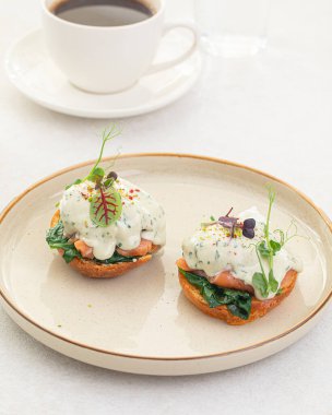 Side view on portion of benedikt egg with dor-blue sauce
