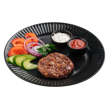 Isolated portion of beef cutlet with sauces and vegetables