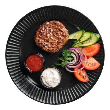 Isolated portion of beef cutlet with sauces and vegetables