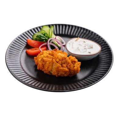 Isolated portion of russian pozharsky cutlet with sauce and vegetables