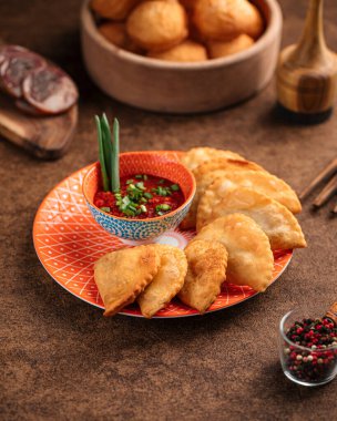 Portion of oriental meat stuffed pies chebureks with sauce