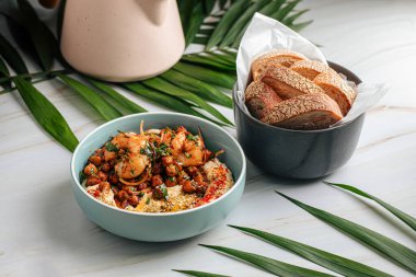 Kızarmış nohut ve karidesli humus kasesi.