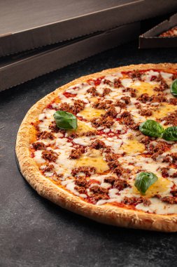 Çedar peyniri ve kıymalı büyük pizzaya yan bakış.