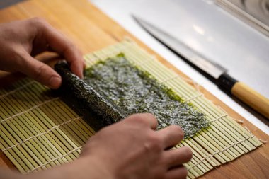 Şef maki suşisi pilav ve nori ile pişiriyor.